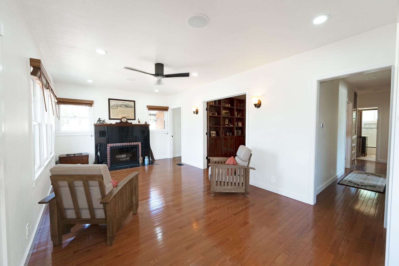 Living room with a black tile fireplace, Mission chairs and hardwood floors