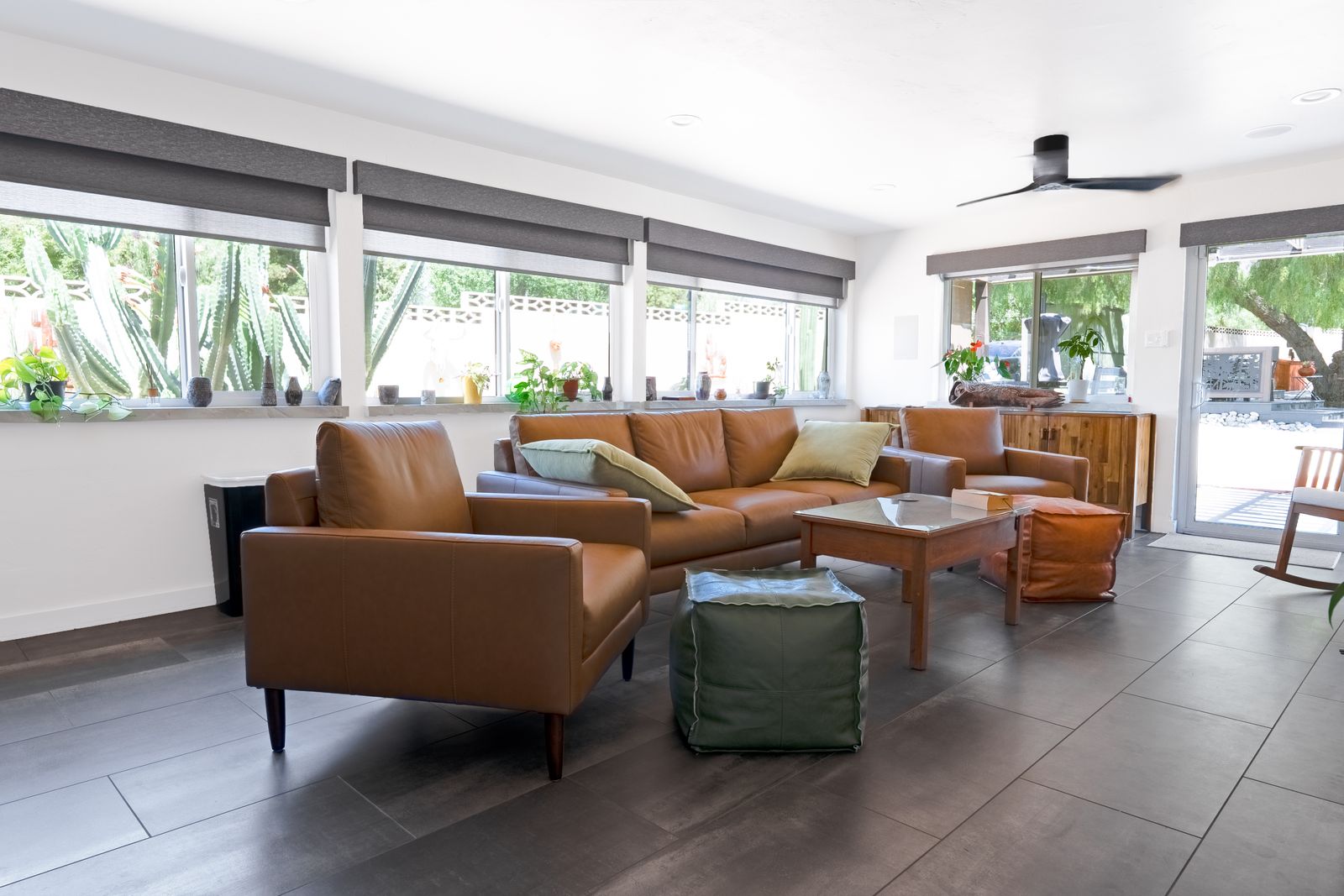 Sunlit family room with leather sofas and a wall of windows